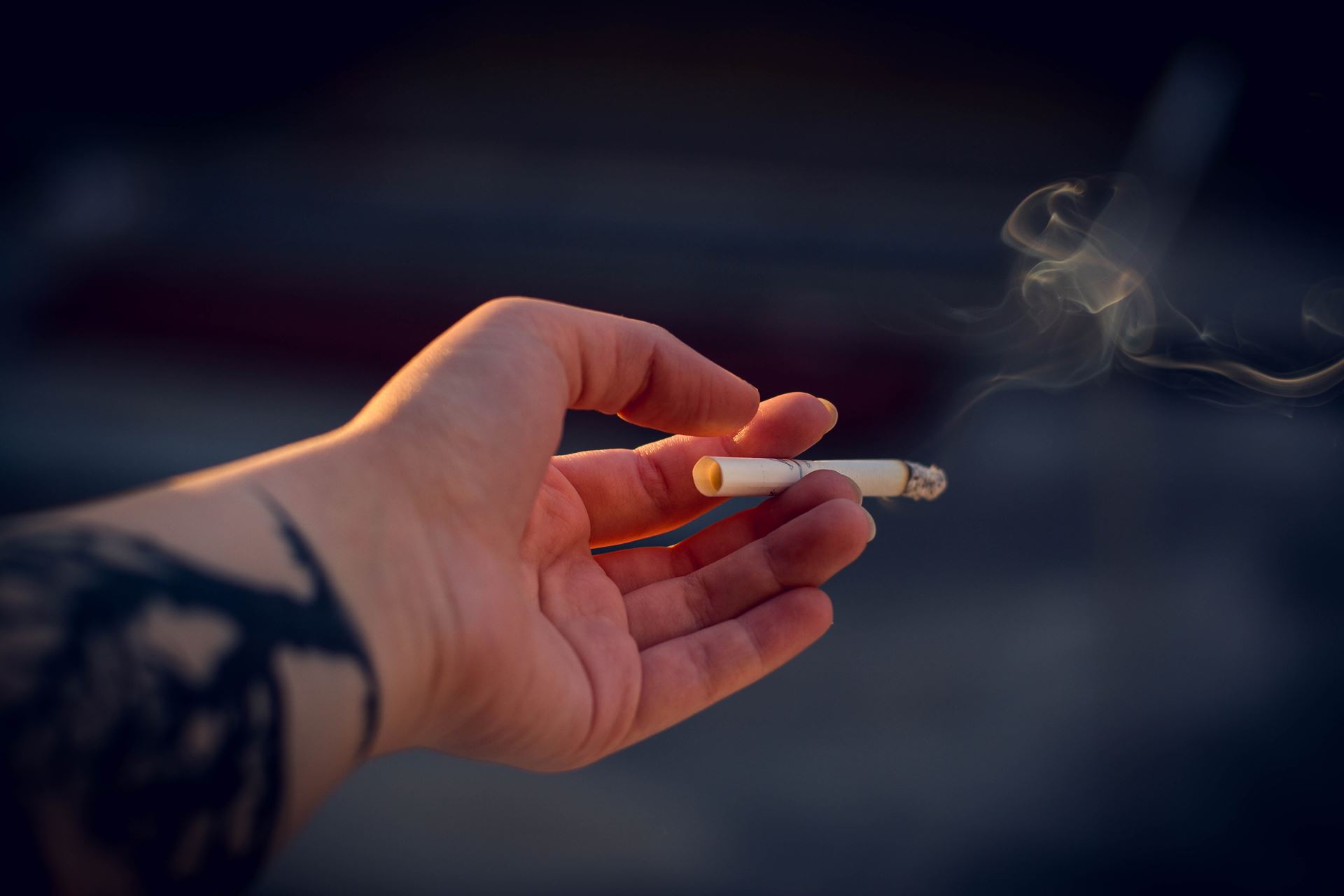 a close up of a hand with a cigarette